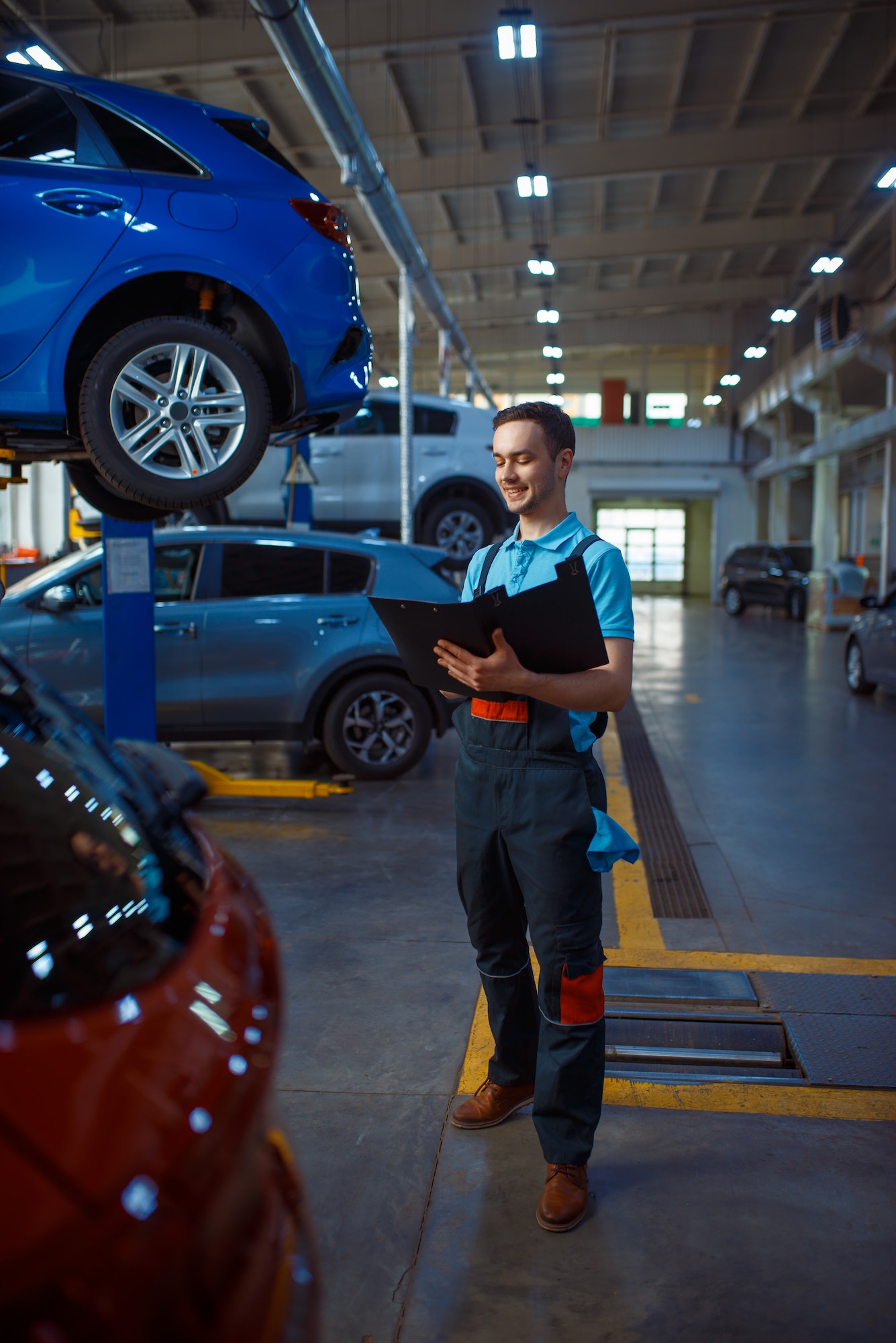 Worker with a checklist, car service station